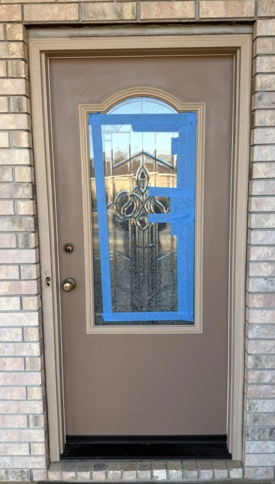 Brown door with blue painter's tape before installation